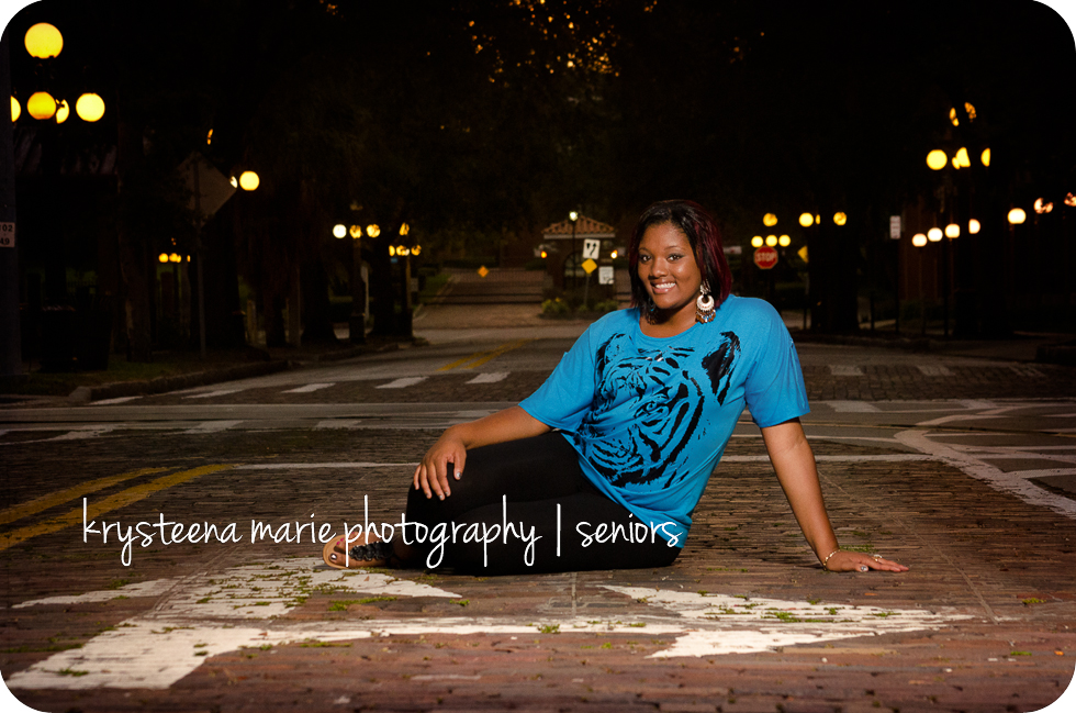 high school senior girl blue tiger shirt sitting in street turn arrows