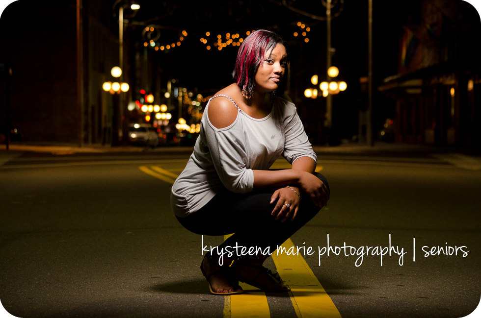 senior portrait girl  crouched in street 7th ave ybor night